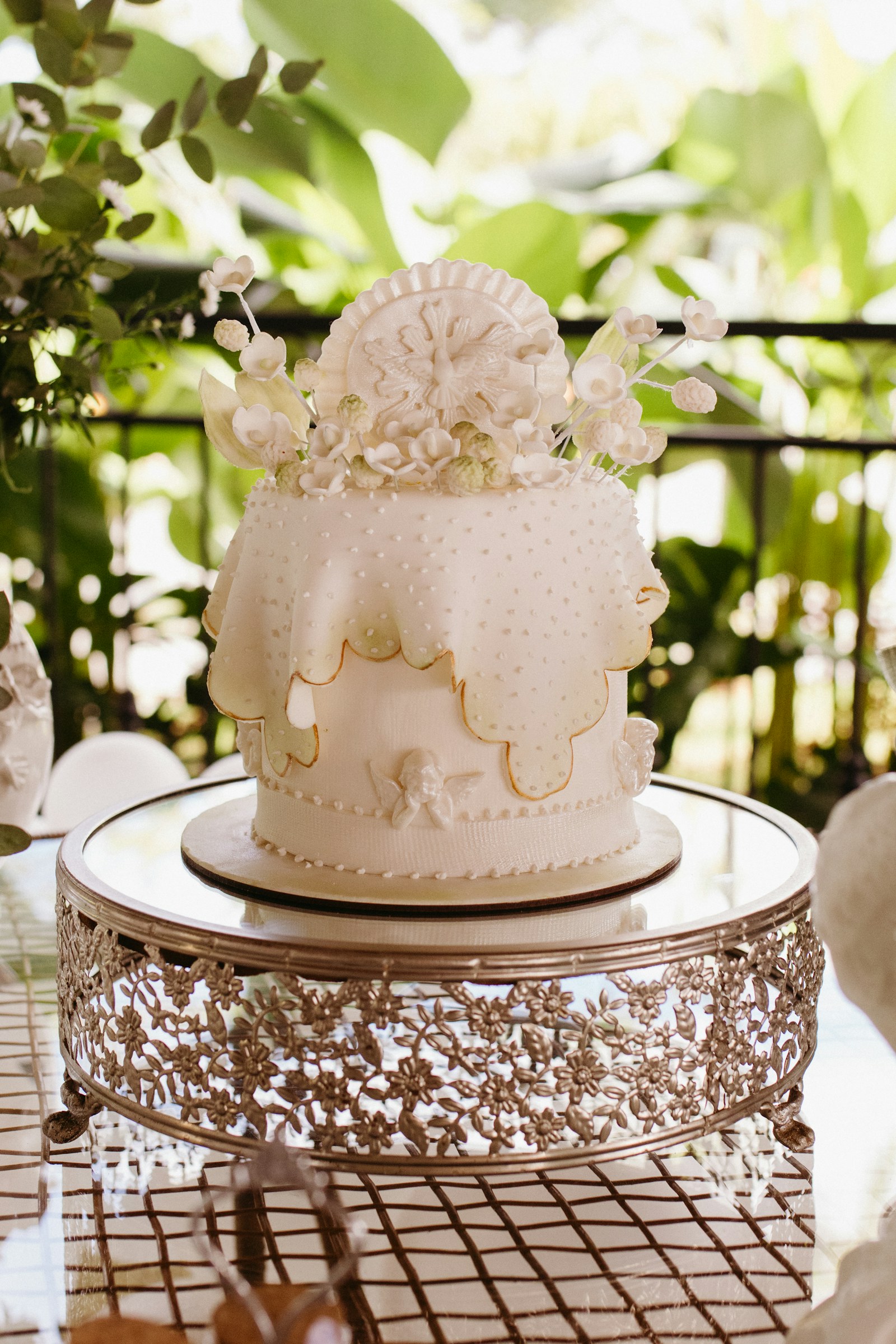 An ornate ivory cake on a vintage silver stand